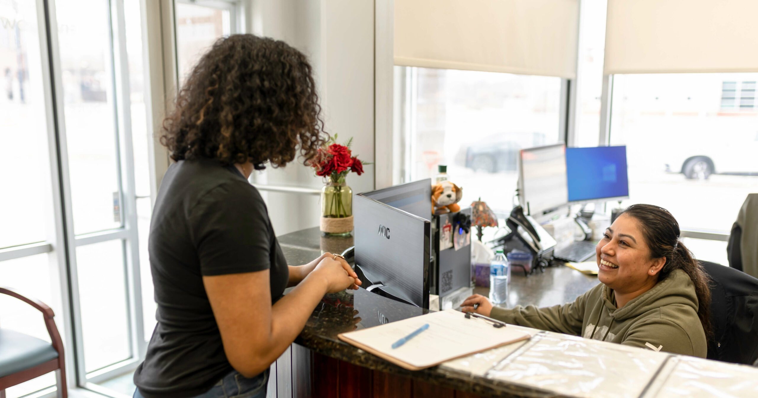 Patient checking in with the office staff of Omaha Health Clinic. 